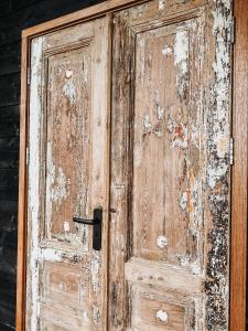 an old wooden door with peeling paint on it at Smûk Tent Huskes in Echtenerbrug