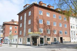 un gran edificio de ladrillo rojo con un cartel. en Strand Hotell, en Vänersborg