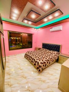 ein Schlafzimmer mit einem Bett in einer rosa Wand in der Unterkunft Royal eagle in Al Rama