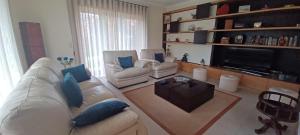 ein Wohnzimmer mit zwei Sofas und einem Fernseher in der Unterkunft Vivenda do Parque Arouca in Arouca
