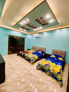 2 Betten in einem Zimmer mit blauen Wänden in der Unterkunft Royal eagle in Al Rama