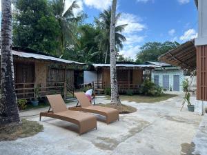 een patio met 2 ligstoelen en palmbomen bij Tribal Xperience Guesthouse in San Vicente