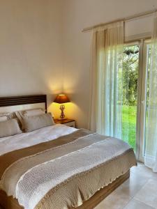a bedroom with a bed and a large window at Olive Dream Thassos Luxury Villas in Skala Rachoniou