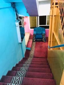 un tramo de escaleras en una habitación con una silla azul en Millat Hotel & Noor Jahan Hotel Kandahar en Kandahār