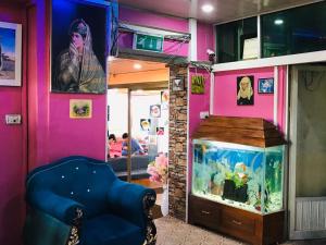 Millat Hotel & Noor Jahan Hotel Kandahar في قندهار: غرفة بها حوض للأسماك وكرسي أزرق