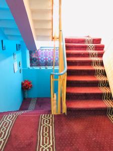 una escalera en un edificio con alfombra roja en Millat Hotel & Noor Jahan Hotel Kandahar en Kandahār