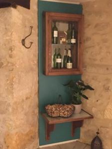 una parete con mensola e bottiglie di vino di Hôtel-Restaurant Côté Rivage a Badefols-sur-Dordogne