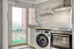 a kitchen with a washing machine next to a window at 642A Apartamento con vistas en Oviedo in Oviedo