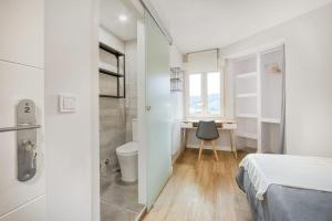a bedroom with a bed and a desk with a chair at 642A Apartamento con vistas en Oviedo in Oviedo