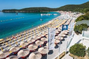 een stel parasols op een strand met water bij Apartman Djordje in Budva