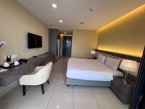 a hotel room with a bed and a desk and a television at Grand Ion Delemen by 91 Homestay in Genting Highlands