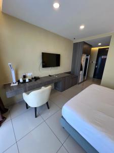 a hotel room with a bed and a desk with a television at Grand Ion Delemen by 91 Homestay in Genting Highlands