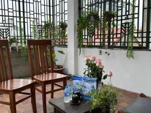 a patio with two chairs and a table with flowers at Quynh Moon homestay in Hanoi