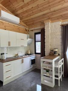 a kitchen with white cabinets and a wooden ceiling at Karadeniz River Palace in Çamlıhemşin