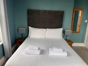 1 dormitorio con 1 cama grande y 2 toallas. en Pentire Hotel en Newquay