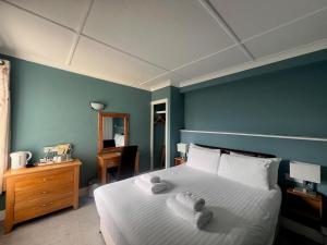 1 dormitorio con cama y pared azul en Pentire Hotel en Newquay