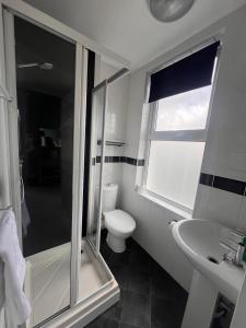 y baño con ducha, aseo y lavamanos. en Pentire Hotel en Newquay