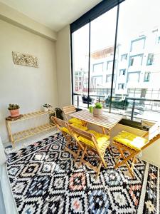 une salle à manger avec une table et des chaises sur un tapis dans l'établissement Lüks Konforlu ve merkezi ev, à Çiftlikköy