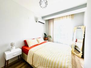 - une chambre blanche avec un lit et un miroir dans l'établissement Lüks Konforlu ve merkezi ev, à Çiftlikköy