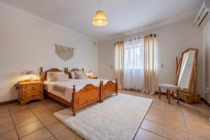 a bedroom with a bed and a dresser and a mirror at Tranquil Mansion - 3 Bed, Pool, BBQ & Gaming Room in Is-Swieqi