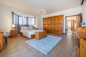 a bedroom with a bed and wooden cabinets at Tranquil Mansion - 3 Bed, Pool, BBQ & Gaming Room in Is-Swieqi +20 photos
