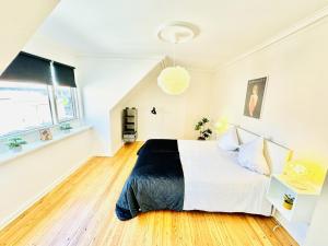 1 dormitorio con 1 cama blanca grande y suelo de madera en aday - 1 bedroom balcony apartment on the pedestrian street in Randers en Randers