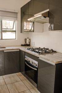 uma cozinha com uma placa de fogão e forno. em No 2 on Cladon Jadde Apartments em Chartwell