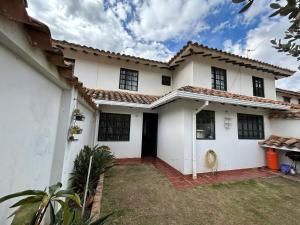 een wit huis met een binnenplaats ervoor bij Acogedora casa en Villa de Leyva in Villa de Leyva