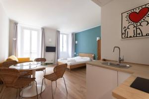 ミラノにあるYouhosty - Ticinese Suite 1のキッチンとテーブルと椅子のあるリビングルーム