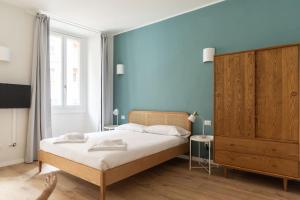 ミラノにあるYouhosty - Ticinese Suite 1の青い壁のベッドルーム1室(ベッド1台付)