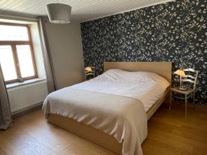 - une chambre avec un lit aux motifs floraux dans l'établissement La croisée des champs, gîte entre Durbuy et La Roche en Ardenne, à Érezée
