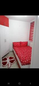 Stella rossa في Modriča: سرير احمر في غرفة بيضاء مع بطانيه حمراء