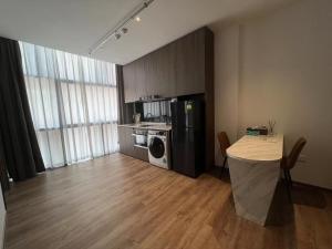 a room with a kitchen with a table and a refrigerator at KK Home - Bugis Service Apartment Suite in Singapore