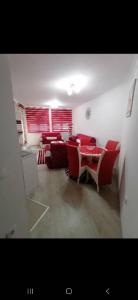Stella rossa في Modriča: غرفة معيشة مع كراسي حمراء وطاولة