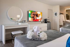 a room with a bed with a mirror and a tv at Magic Moment Resort and Kids Club in Kissimmee