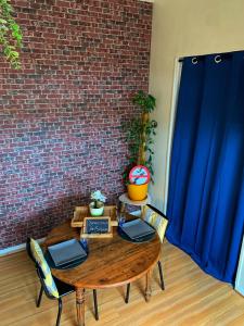 a wooden table with two laptops on it next to a brick wall at Appartement agreable et zen in Boulogne-sur-Mer