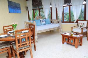 ein Wohnzimmer mit einer Couch und einem Tisch und Stühlen in der Unterkunft Tembo Court Beach Cottage in Malindi