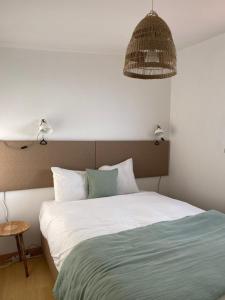 1 dormitorio con 1 cama y luz colgante en Azenhas do Mar Beach House, en Sintra