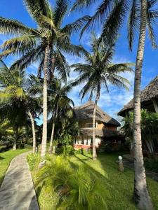 ein Haus mit Palmen davor in der Unterkunft Tembo Court Beach Cottage in Malindi