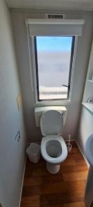 a small bathroom with a toilet and a window at NEW Orla Caravan in Meliden