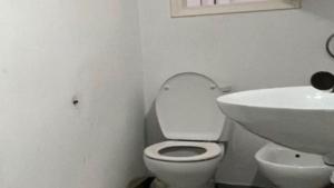 een witte badkamer met een toilet en een wastafel bij Apartamento Agost Illes Balears in Ibiza-stad