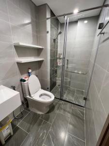 a bathroom with a toilet and a glass shower at Resort Ori Vinhomes Grand Park tp Thủ Đức , 3giường 2WC in Long Bình