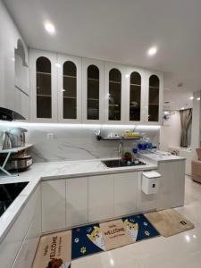 a kitchen with white cabinets and a kitchen rug at Resort Ori q9 3, giường, 2pn+ 2wc in Long Bình