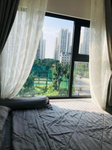 a bedroom with a bed and a large window at Resort Ori q9 3, giường, 2pn+ 2wc in Long Bình