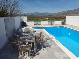 a patio with a table and chairs next to a pool at Villa SUNFLOWER in Mostar