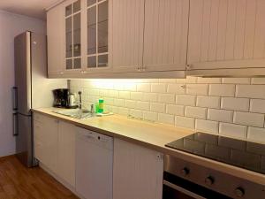 a kitchen with white cabinets and a counter top at Enjoy Entire Condo near Stavanger airport in Sola