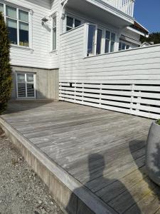 Enjoy Entire Condo near Stavanger airport في سولا: سطح خشبي أمام المنزل