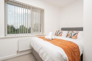 a white bedroom with a large window and a bed at Exquisite Mcr City Centr Gem - Foosball - Sleeps11 in Manchester