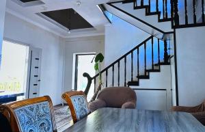 科奇科尔Guest House Umar的一间带桌子和楼梯的用餐室