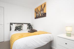a bedroom with a large bed with white walls at Exquisite Mcr City Centr Gem - Foosball - Sleeps11 in Manchester